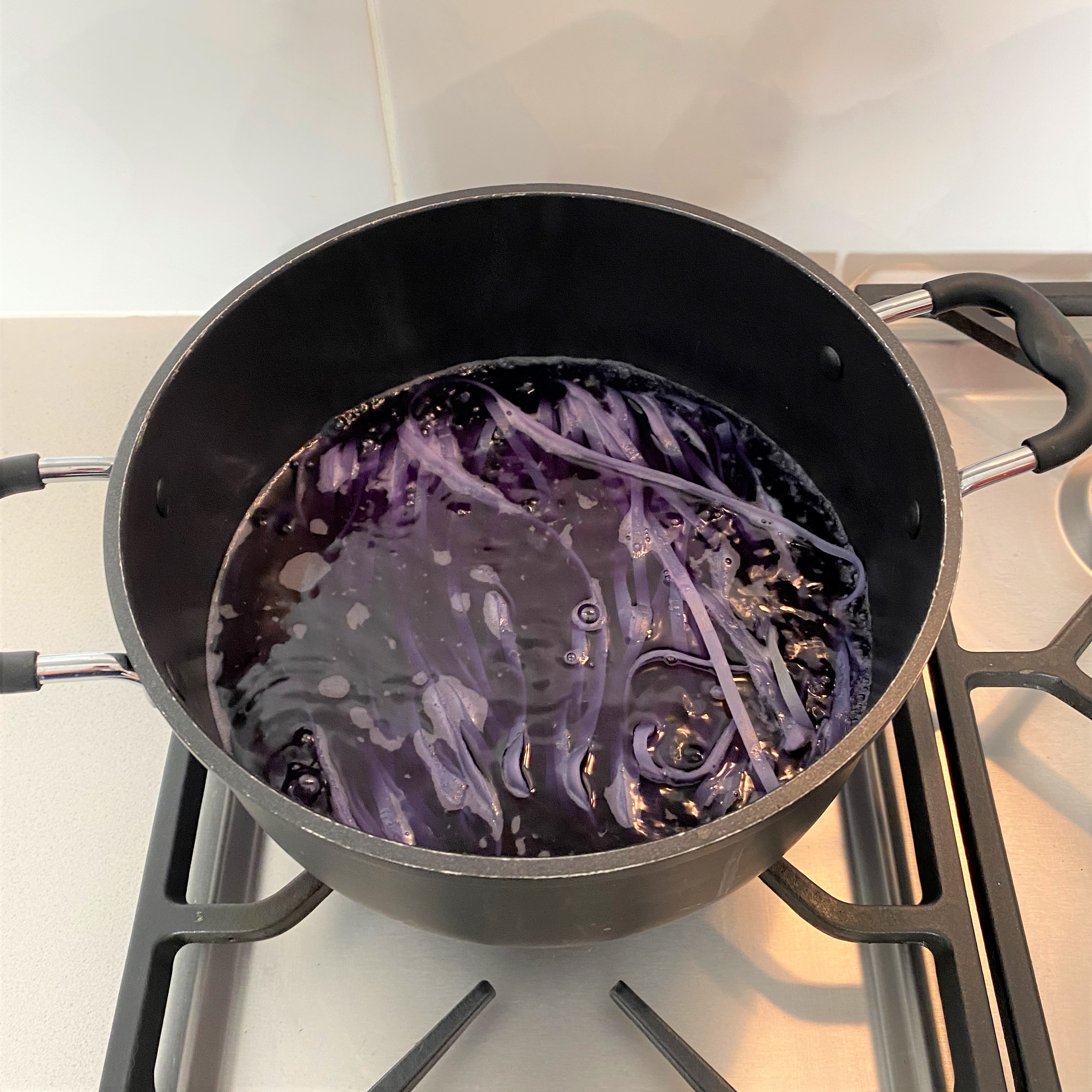 Noodles cooking in purple water